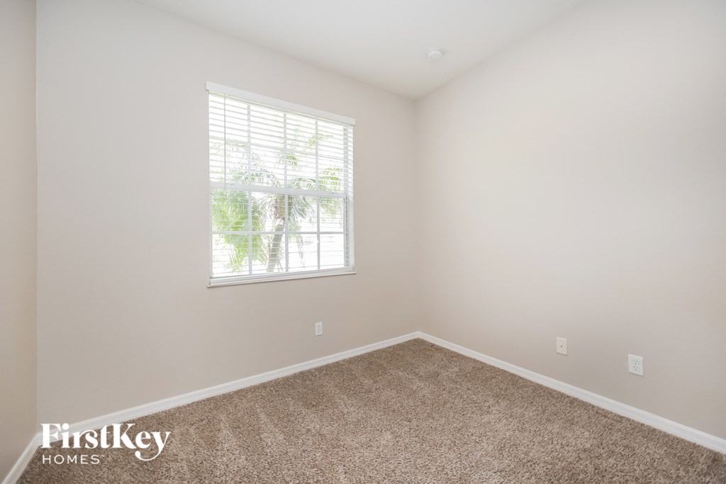 a bedroom with a carpeted floor and a window