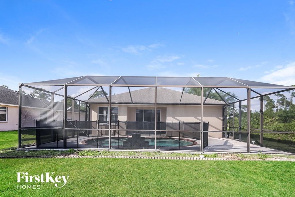 a glass conservatory with a pool in front of a house