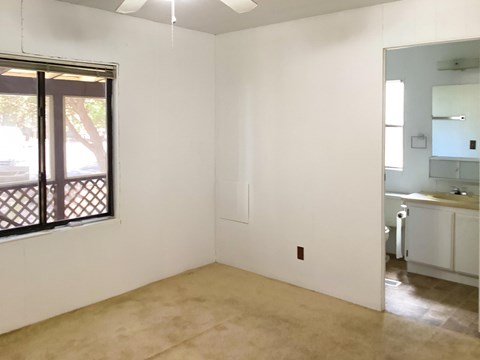 A room with a sliding glass door and a ceiling fan.