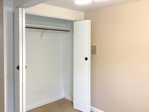 A white door is open to a room with a carpeted floor.