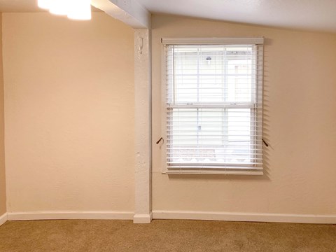 A room with a window covered in blinds.
