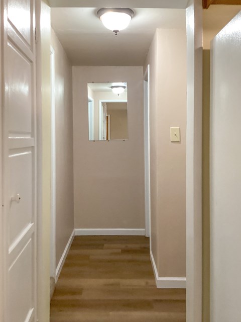 A long hallway with a mirror at the end.