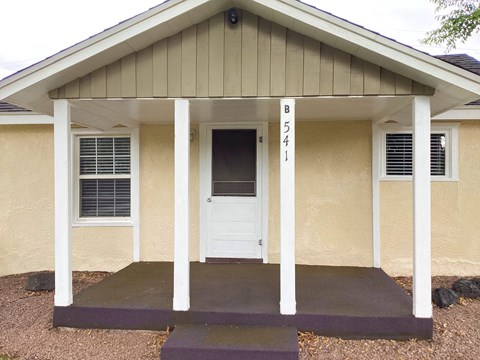 A small house with a porch and a door with the number 541 on it.