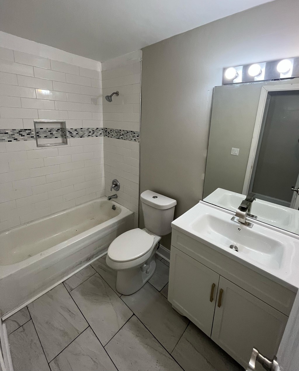 A white bathroom with a toilet, sink, and bathtub.