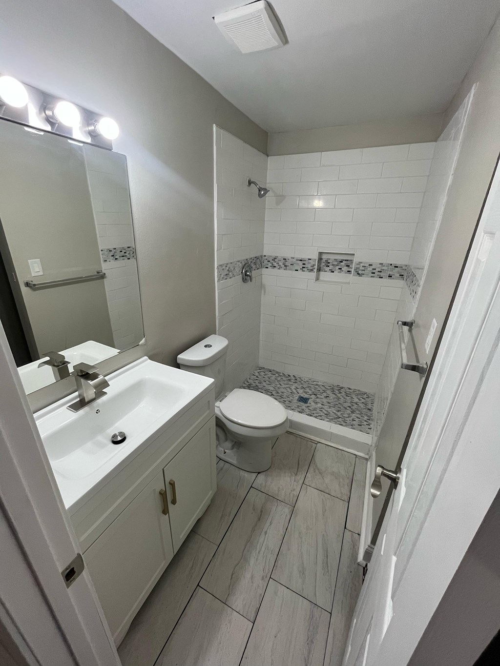 A white bathroom with a toilet, sink, and shower.