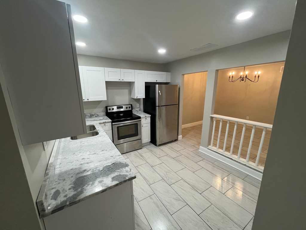 A kitchen with a refrigerator, oven, and microwave.