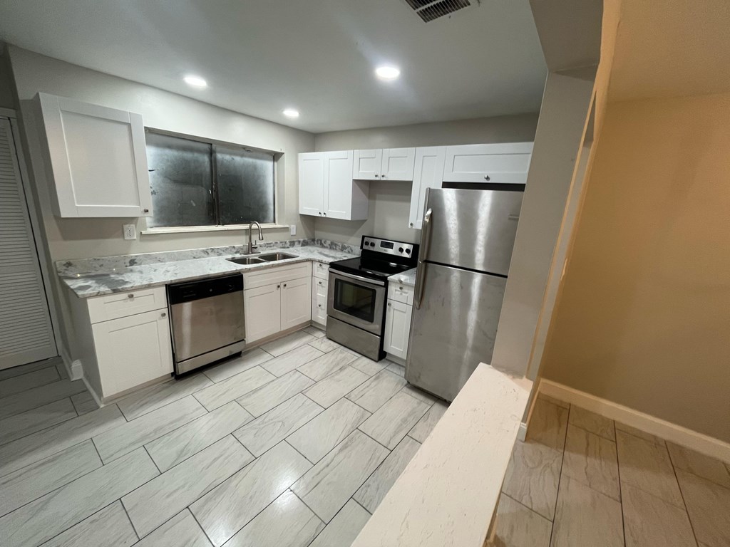 A kitchen with white cabinets and stainless steel appliances.