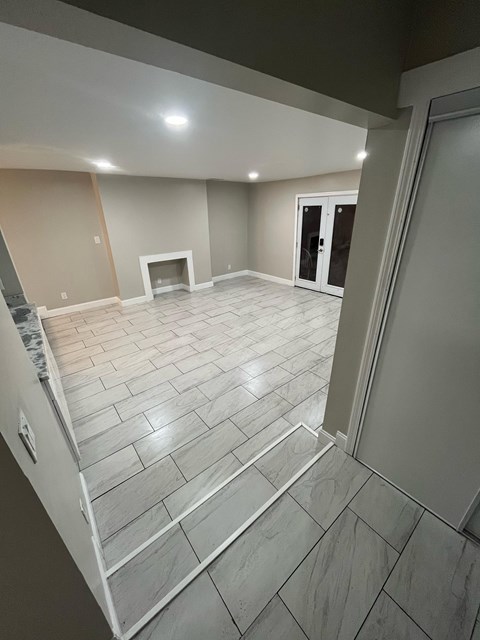 A room with a fireplace and tiled flooring.
