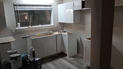 a kitchen being remodeled with white cabinets and a window