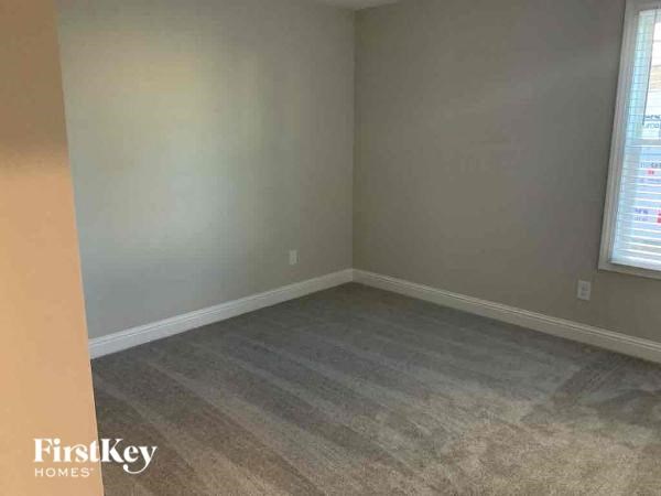 an empty room with a carpeted floor and two windows