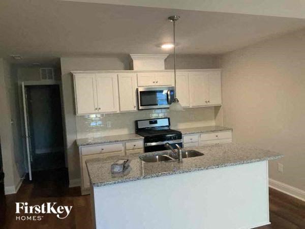 a kitchen with white cabinets and a granite counter top