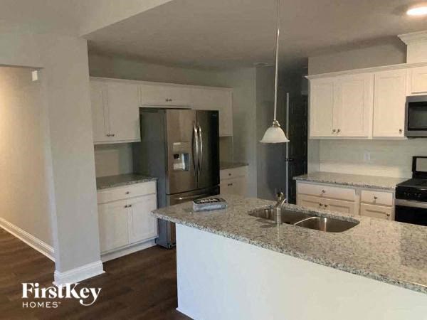 a kitchen with white cabinets and a granite counter top