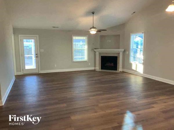 an empty living room with wood floors and a fireplace