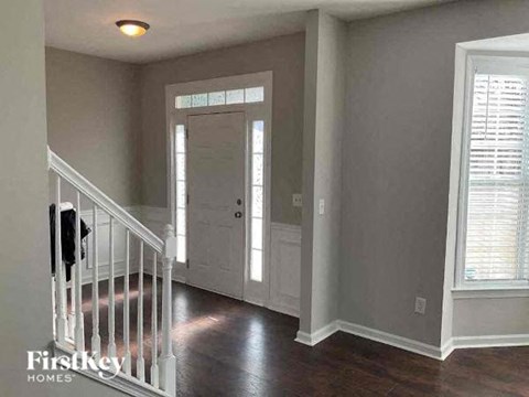 a hallway with a staircase and a white door