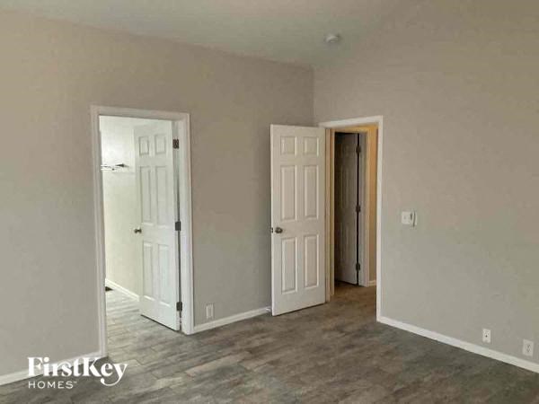 a empty living room with two doors and a wood floor