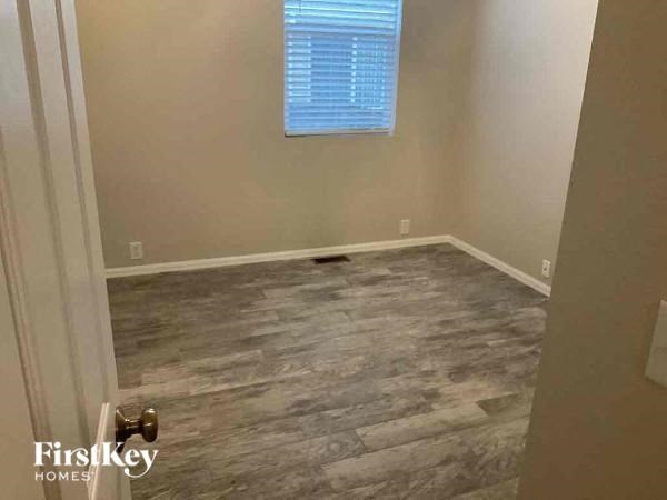 an empty room with wood floors and a window