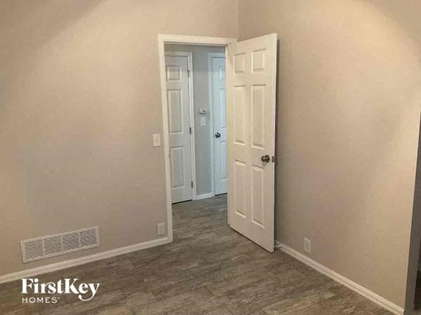 a hallway with an open door and a door to a closet