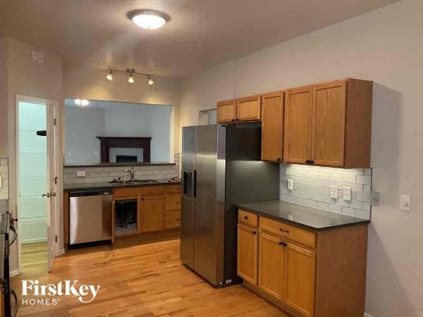 a kitchen with wooden cabinets and a stainless steel refrigerator