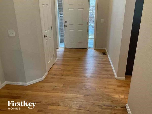 a hallway with a wooden floor and a white door