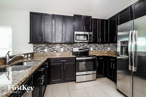 A kitchen with black cabinets and stainless steel appliances.