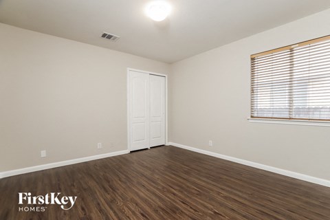 the living room of a home with wood flooring and a window