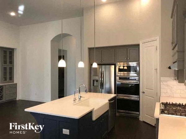 A kitchen with a white countertop and dark cabinets.