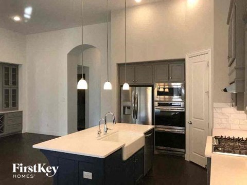 A kitchen with a white countertop and dark cabinets.