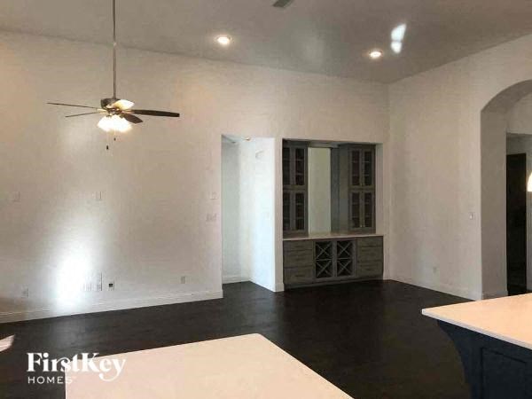 A spacious room with a ceiling fan and a large window.