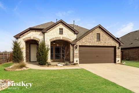 A house with a garage and a driveway in front of it.