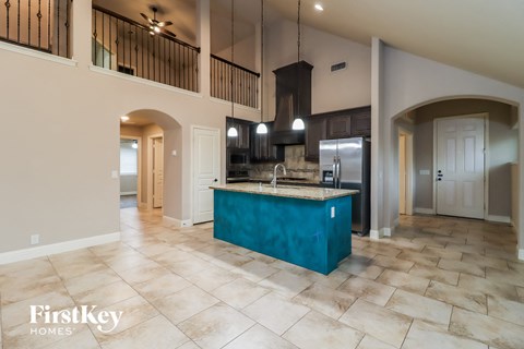 A kitchen with a blue island and a tiled floor.