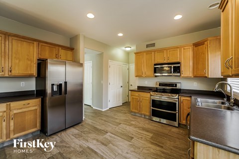 A kitchen with wooden cabinets and a stainless steel refrigerator.