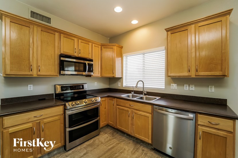 A kitchen with wooden cabinets and a stainless steel dishwasher.