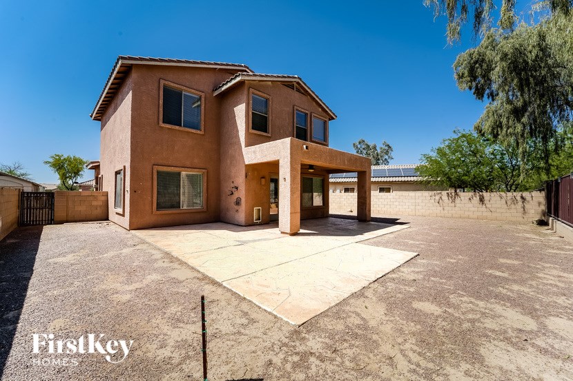 A large house with a brown exterior and a large driveway in front.