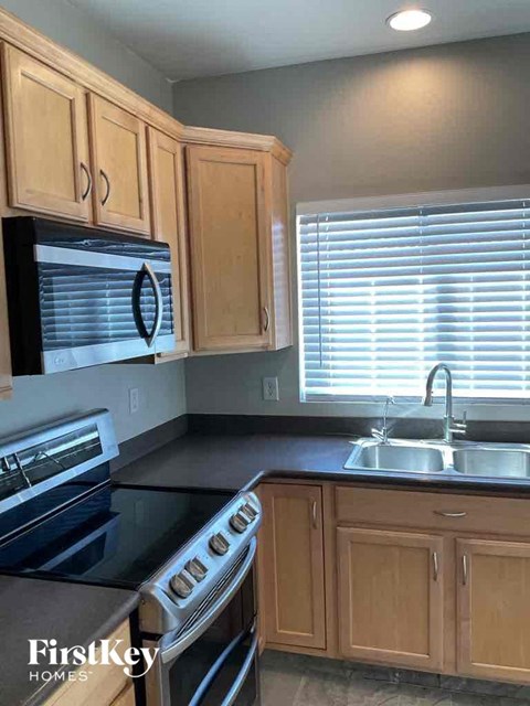 a kitchen with wooden cabinets and a stove and a sink