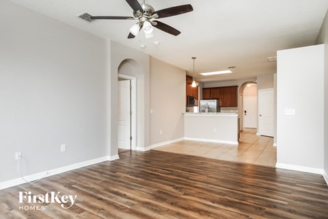 A spacious room with a ceiling fan and wooden flooring.
