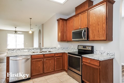 A kitchen with wooden cabinets and a stainless steel dishwasher.