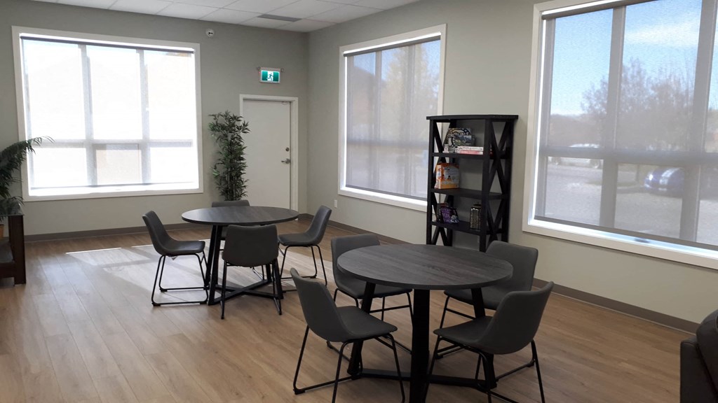 A room with a table and chairs and a plant.
