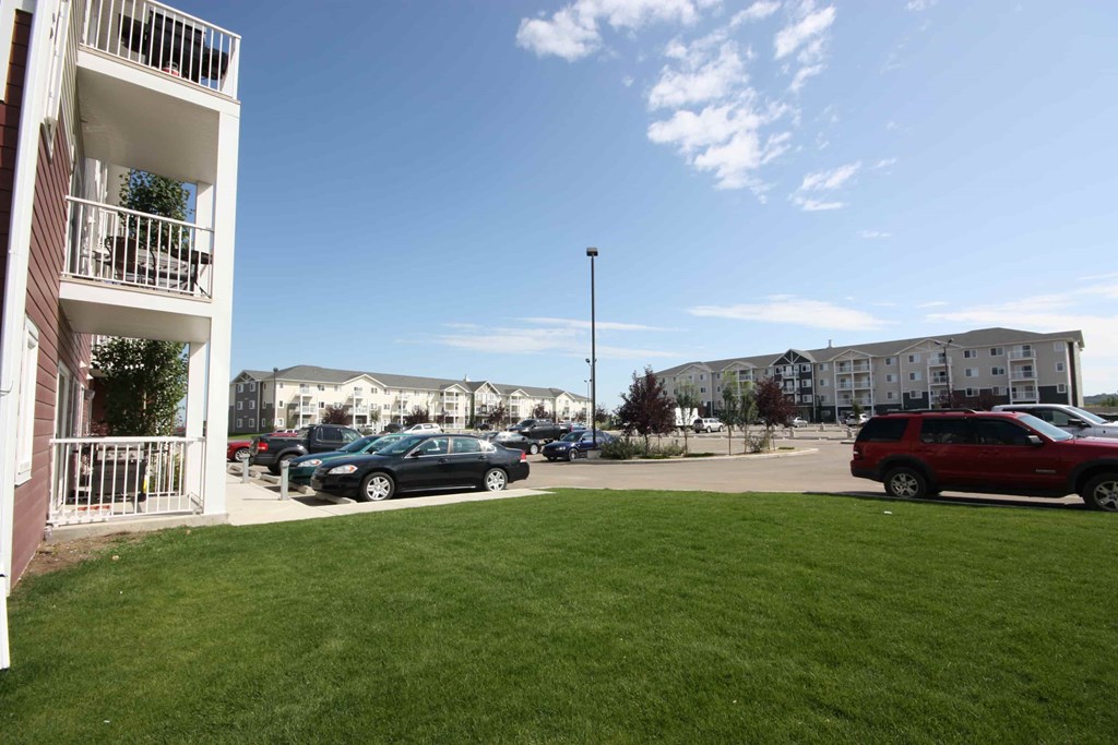 A parking lot with cars and a building in the background.