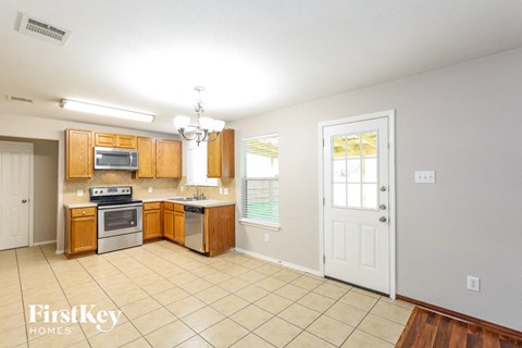 A kitchen with wooden cabinets and a white door.