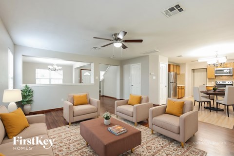 A living room with a brown coffee table and beige couches.