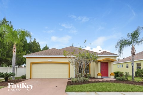 a yellow house with a driveway and a yellow garage door