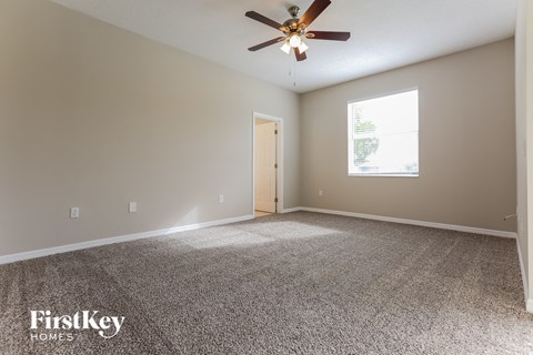 a living room with carpet and a ceiling fan