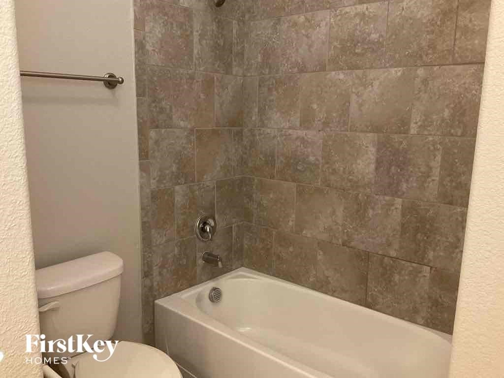 a bathroom with a toilet and a bath tub