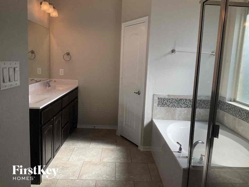 a bathroom with a tub and a sink and a shower