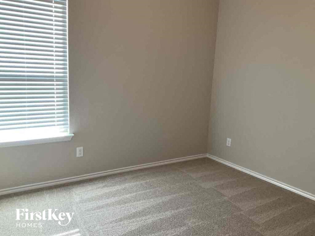 an empty room with a window and a carpeted floor