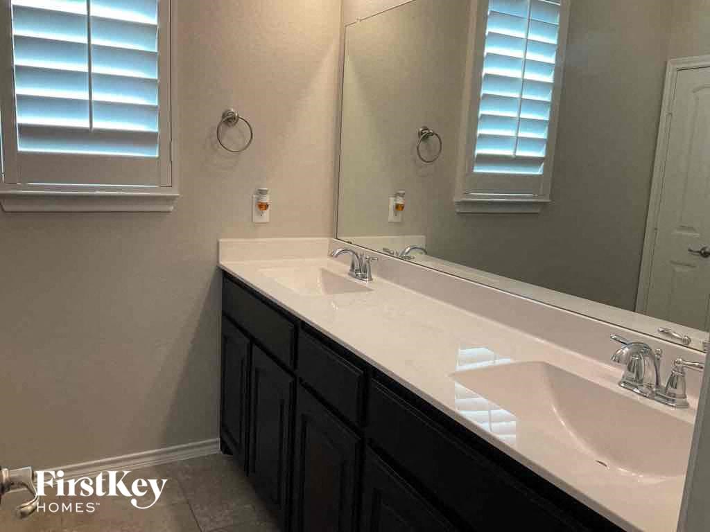 a bathroom with two sinks and a large mirror