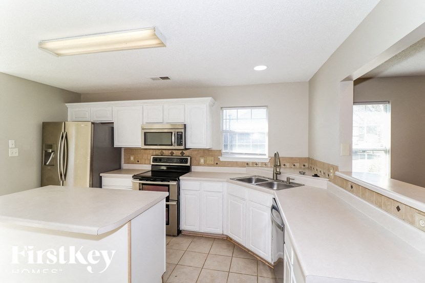 A kitchen with white appliances and cabinets.