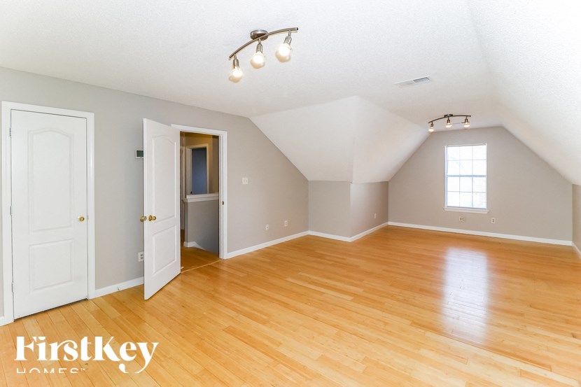 A room with wooden floors and a window is shown.