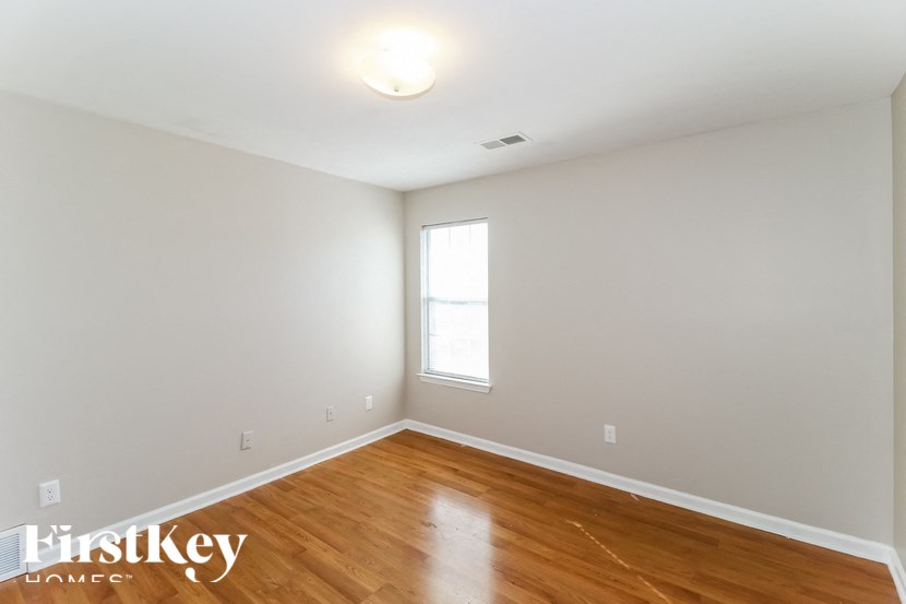 A room with wooden floors and a window letting in light.