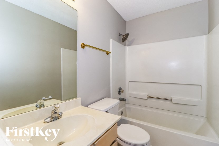 A white bathroom with a toilet, sink, and bathtub.